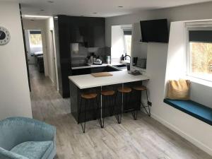 a kitchen with a counter and stools in a room at Riverside Hideaway in Kincraig