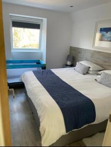 a bedroom with two beds and a window at Riverside Hideaway in Kincraig