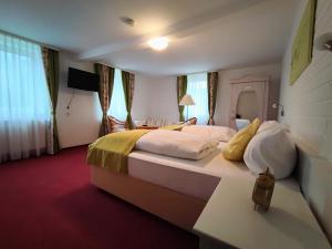 una habitación de hotel con una cama grande con almohadas amarillas y blancas en Room in Guest room - Pension Forelle - double room no01, en Forbach