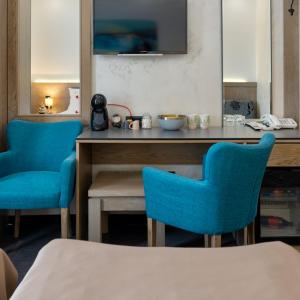 Habitación con 2 sillas azules y mesa. en Studio u Hotelu Alibi Inn, en Zlatibor