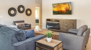 sala de estar con 2 sofás y TV en Boho Chic Arizona Villa w Pool & Mini Golf en Casa Grande