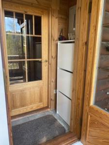 a refrigerator in a room with a wooden door at Latvahonka Cottage in Jämsä +23 photos