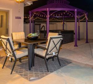 una mesa de madera con sillas y un cenador en Boho Chic Arizona Villa w Pool & Mini Golf en Casa Grande