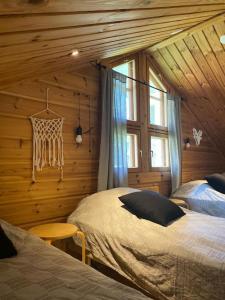 a bedroom with two beds in a log cabin at Latvahonka Cottage in Jämsä
