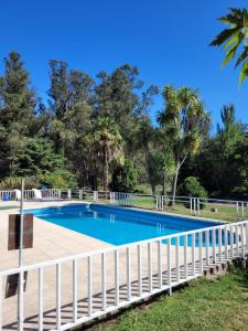 a swimming pool with a white fence around it at VILLAGE PARK in Tandil