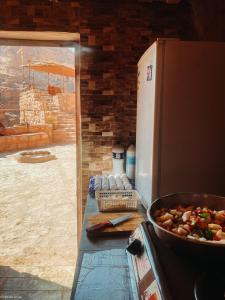 a kitchen with a refrigerator and a bowl of food at Indiana Jones Cave in ‘Ayn Amūn