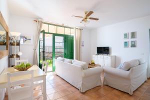 salon z 2 białymi kanapami i stołem w obiekcie Casa Vela Marina, Puerto Calero w mieście Puerto Calero