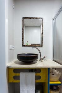 baño con lavabo negro y espejo en Ático con terraza y vistas al mar., en A Coruña