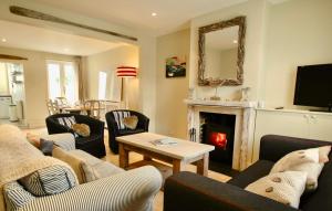 a living room with couches and a fire place at Seakale Cottage in Rye Harbour