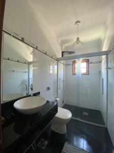 a bathroom with a sink and a toilet and a mirror at Pousada Banzay in Paraty