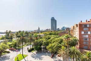uitzicht op een stad met palmbomen en gebouwen bij Idyllic apartment in BCN beach in Barcelona