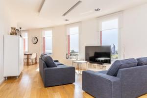 a living room with two blue couches and a television at Idyllic apartment in BCN beach in Barcelona