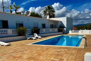 Villa con piscina frente a una casa en Blue Skies Villas 1&2, en Mexilhoeira Grande