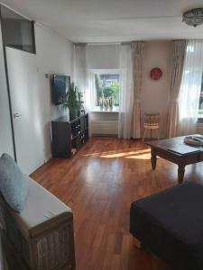 a living room with a couch and a table at House close to beach and the city of Hoorn in Hoorn