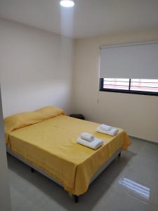 a bedroom with a bed with two towels on it at Alpaquitay 1 in Mendoza