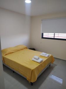 1 dormitorio con 1 cama con 2 toallas en Alpaquitay 1 en Mendoza