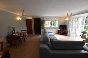 uma sala de estar com um sofá e uma sala de jantar em Canalside Manor House Annexe with Secure Parking 