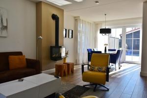 a living room with a couch and a tv and a table at Woning zeldenrust 6 in Oostkapelle