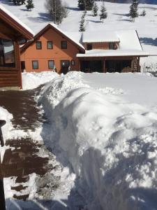 a pile of snow in front of a house at Csángó Panoráma in Valea Rece