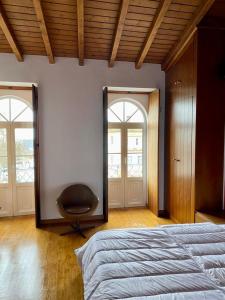 1 dormitorio con espejo y silla en Casa da Joana by Portus Alacer, en Portalegre