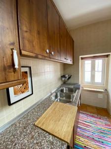 uma cozinha com um lavatório e uma bancada em Casa da Joana by Portus Alacer em Portalegre