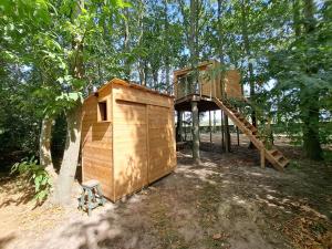 a wooden play house with a tree at De Koekoek in Bruges