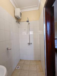 a bathroom with a shower with a toilet at Kasenene Legacy Hotel in Fort Portal