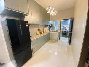 a kitchen with a black refrigerator and a microwave at Haira Muslim Homestay in Pasir Gudang