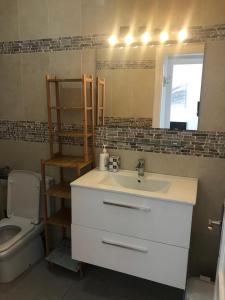 a bathroom with a sink and a toilet and a mirror at Los tunos campo internacional in Maspalomas