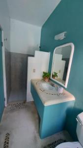 a blue bathroom with a sink and a mirror at Delphinus Inn in Santa Cruz Huatulco