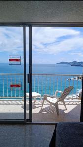 a view of the ocean through a sliding glass door at Suite Claus in Acapulco