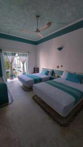a bedroom with two beds and a ceiling at Delphinus Inn in Santa Cruz Huatulco
