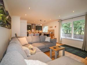 a living room with a couch and a table at Stewart's Cottage, Aviemore Centre in Aviemore