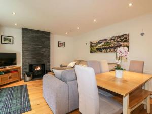 a living room with a couch and a table and a fireplace at Stewart's Cottage, Aviemore Centre in Aviemore