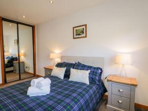 a bedroom with a bed with two towels on it at Stewart's Cottage, Aviemore Centre in Aviemore