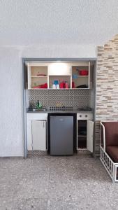 a kitchen with white cabinets and a couch at Suite Claus in Acapulco