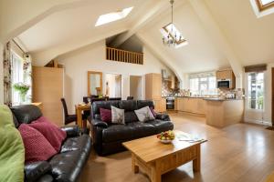 a living room with a couch and a table at The Country Lodge at Hill House Farm Cheshire in Tarporley