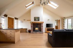 a living room with a fireplace and a couch at The Country Lodge at Hill House Farm Cheshire in Tarporley