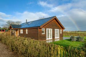 塔博雷的住宿－The Country Lodge at Hill House Farm Cheshire，一座带太阳能屋顶的小型木屋