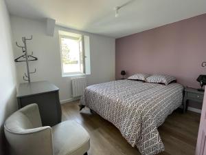 ein Schlafzimmer mit einem Bett, einem Stuhl und einem Fenster in der Unterkunft Le Logis de la Place in Thouars
