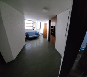 Departamento en el centro de Mendoza في ميندوزا: ممر مع أريكة زرقاء في غرفة المعيشة