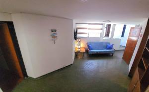 Departamento en el centro de Mendoza في ميندوزا: مدخل مع كرسي أزرق في غرفة