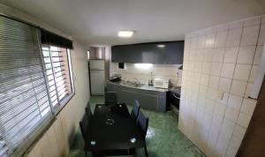 Departamento en el centro de Mendoza في ميندوزا: مطبخ صغير مع كرسي أسود في الغرفة
