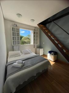um quarto com uma cama grande e uma janela em Pousada Província em Lavras Novas