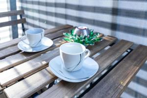 dos tazas de café y platillos en una mesa de madera en 263 Zentrum Nord Apartment Messe,Hbf,A14, en Leipzig