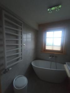 a bathroom with a large tub and a window at Dom z bala in Lipowa