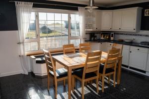 a kitchen with a wooden table and chairs and a window at Atlantic views at Arnisdale House 