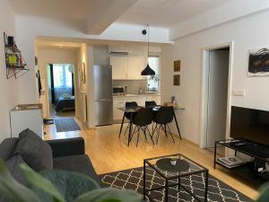 un soggiorno con divano e tavolo e una cucina di Boennium Apartments Green Oasis a Lubiana