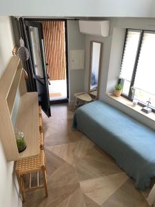 a bedroom with a blue bed and windows at La Suite du Héron nantais in Nantes