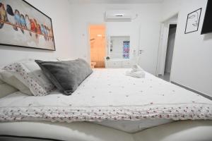 ein Schlafzimmer mit einem großen weißen Bett mit Blumen darauf in der Unterkunft דירה luxury על הפארק חניה חינם in Migdal Afeq